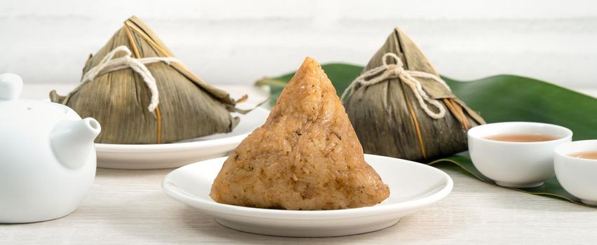 Zongzi. Rice dumpling for Chinese traditional Dragon Boat Festival (Duanwu Festival)  on bright wooden table background.