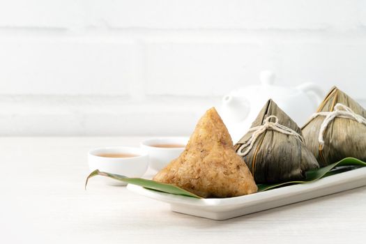 Zongzi. Rice dumpling for Chinese traditional Dragon Boat Festival (Duanwu Festival)  on bright wooden table background.