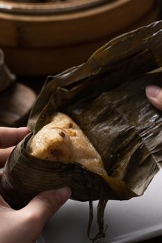 Eating Zongzi rice dumpling for Chinese traditional Dragon Boat Festival (Duanwu Festival) celebration event concept.