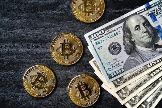 Business top view design concept of cryptocurrency bitcoin with USD Dollar paper currency money over dark black table background.