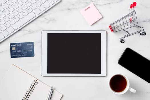 Top view of online shopping concept with credit card and electronics isolated on office marble white table background.