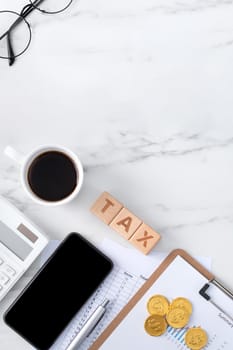 Top view of reading the overview and calculating, paying tax with smart phone from internet.