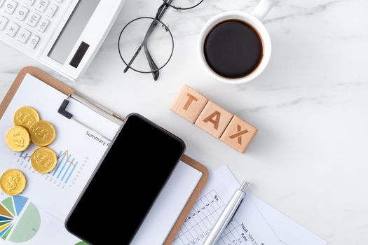 Top view of reading the overview and calculating, paying tax with smart phone from internet.