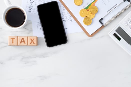 Top view of reading the overview and calculating, paying tax with smart phone from internet.