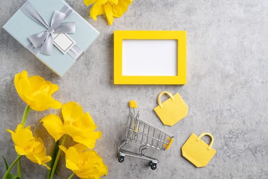Concept of Mother's day holiday gift shopping greeting design with yellow tulip flower bouquet on gray background