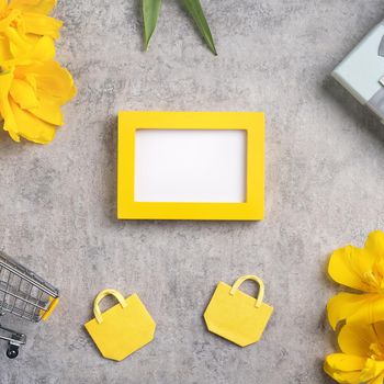 Concept of Mother's day holiday gift shopping greeting design with yellow tulip flower bouquet on gray background