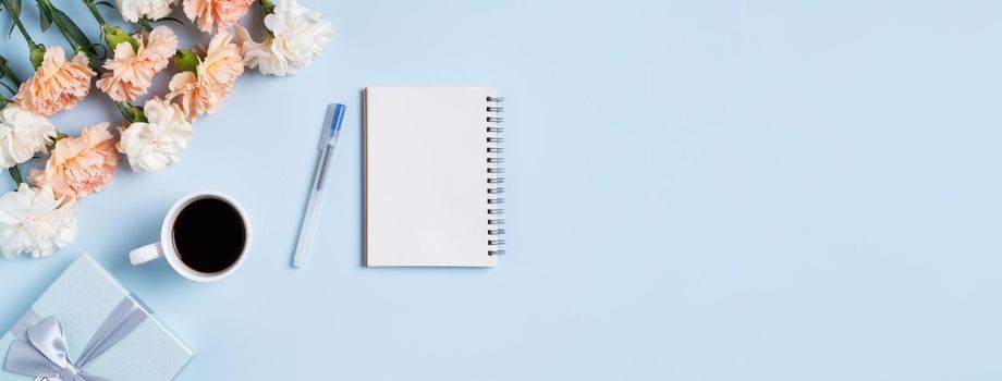 Design concpet of Mother's Day greeting with carnation flower, holiday gift idea and notebook diary on mother's desk background.