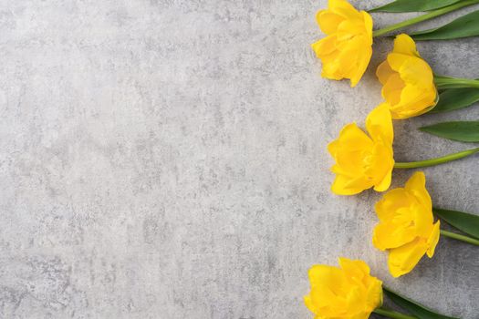 Concept of Mother's day holiday greeting design with yellow tulip flower bouquet on gray background