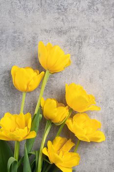 Concept of Mother's day holiday greeting design with yellow tulip flower bouquet on gray background