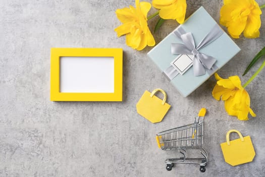 Concept of Mother's day holiday gift shopping greeting design with yellow tulip flower bouquet on gray background