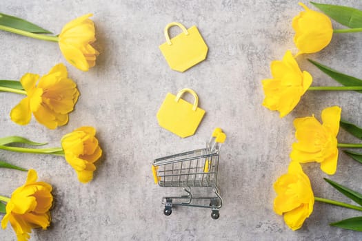 Concept of Mother's day holiday gift shopping greeting design with yellow tulip flower bouquet on gray background