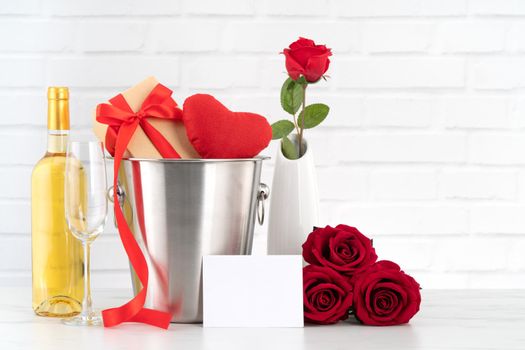 Valentine's Day celebration with wine, gift and rose bouquet for holiday greeting.