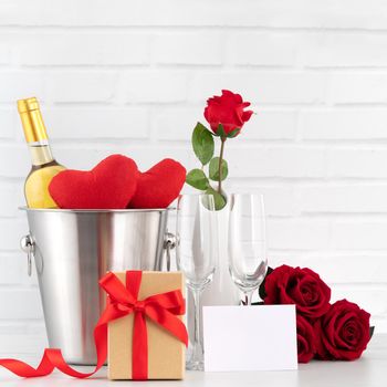 Valentine's Day celebration with wine, gift and rose bouquet for holiday greeting.