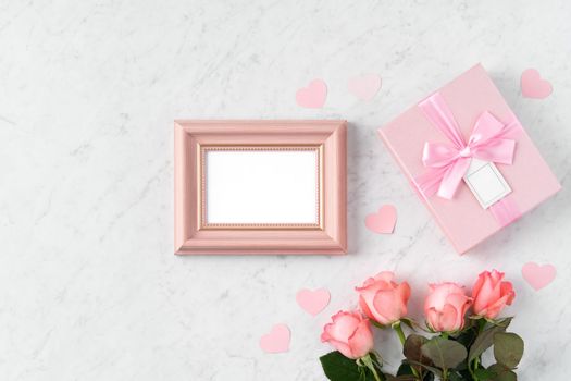 Giftbox and pink rose flower on marble white table background for Valentine's Day holiday greeting design concept.