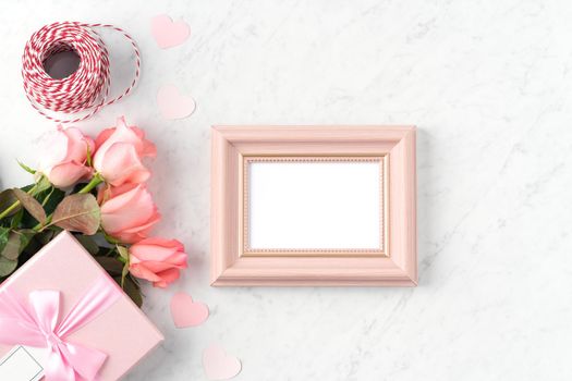 Giftbox and pink rose flower on marble white table background for Valentine's Day holiday greeting design concept.