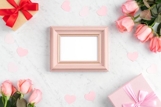 Giftbox and pink rose flower on marble white table background for Valentine's Day holiday greeting design concept.