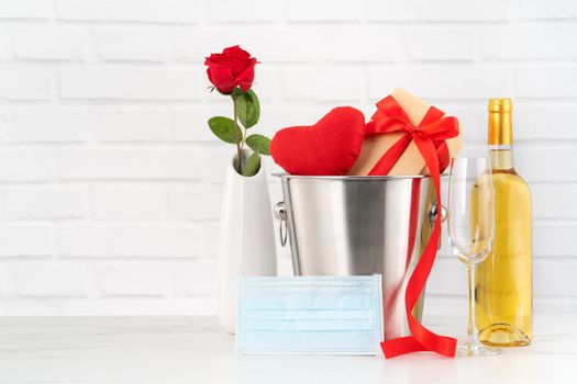 Valentine's Day celebration with wine, bouquet and face mask protection concept during this hard time.