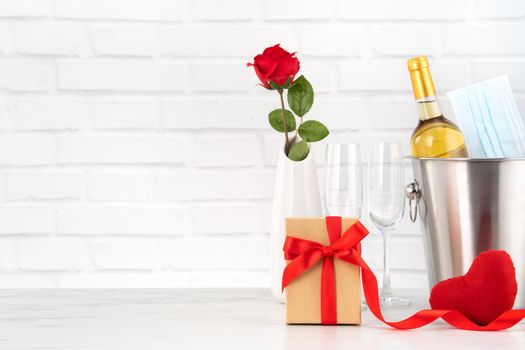 Valentine's Day celebration with wine, bouquet and face mask protection concept during this hard time.