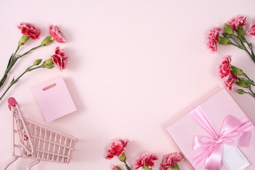 Concept of Mother's day holiday greeting design with carnation bouquet and gift on pink background