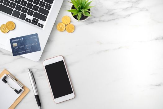 Top view of financial plan concept with credit card, laptop, note on white office table background.