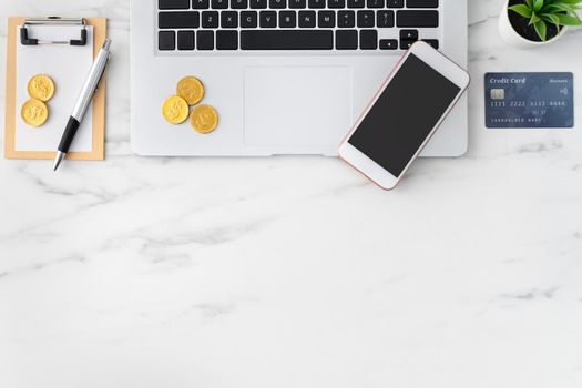 Top view of financial plan concept with credit card, laptop, note on white office table background.