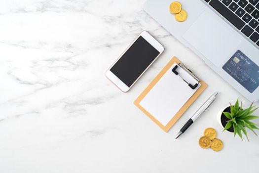 Top view of financial plan concept with credit card, laptop, note on white office table background.