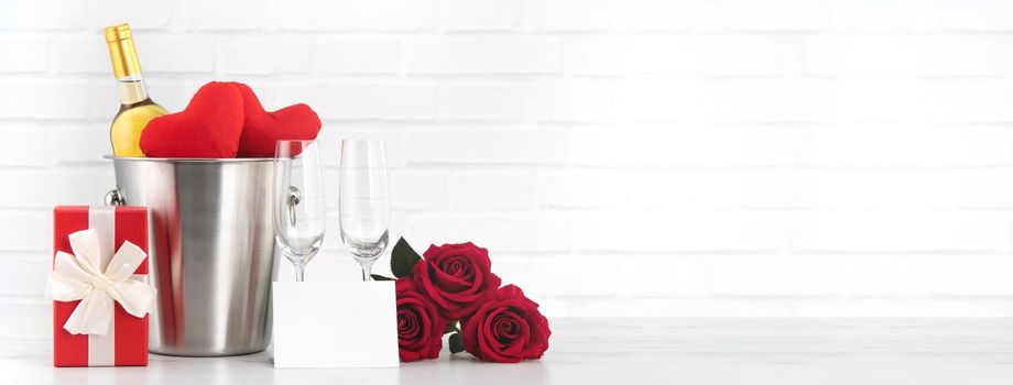 Valentine's Day celebration with wine, gift and rose bouquet for holiday greeting.