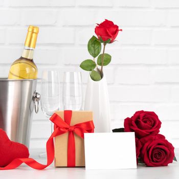 Valentine's Day celebration with wine, gift and rose bouquet for holiday greeting.