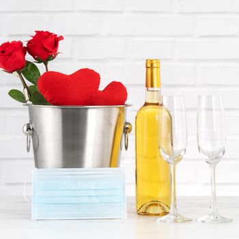 Valentine's Day celebration with wine, bouquet and face mask protection concept during this hard time.