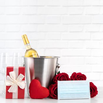 Valentine's Day celebration with wine, bouquet and face mask protection concept during this hard time.