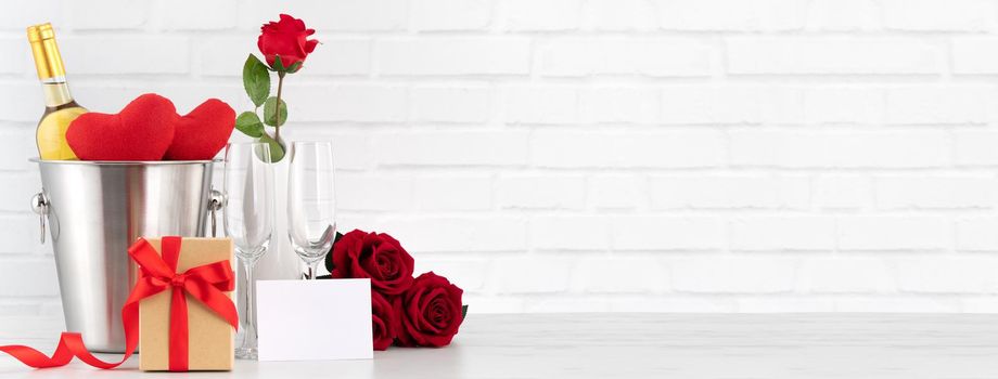 Valentine's Day celebration with wine, gift and rose bouquet for holiday greeting.