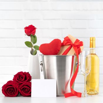 Valentine's Day celebration with wine, gift and rose bouquet for holiday greeting.