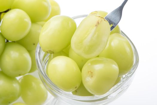 Close up of beautiful Shrine Muscat green grape in a glass cup isolated on white background, clipping path cut out.