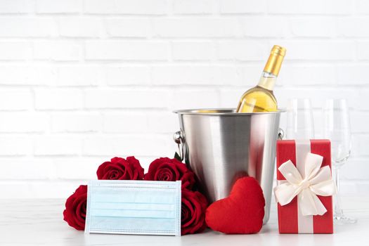 Valentine's Day celebration with wine, bouquet and face mask protection concept during this hard time.