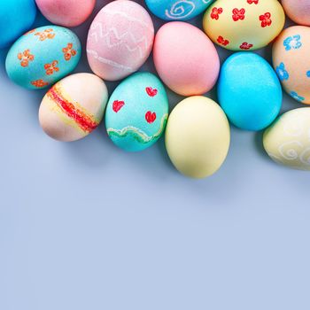 Colorful Easter hunting eggs dyed by colored water with beautiful pattern on pastel blue background, design concept of holiday.