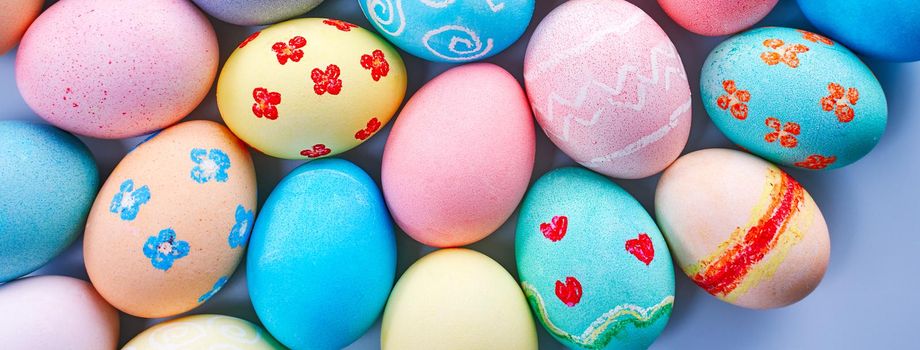 Colorful Easter hunting eggs dyed by colored water with beautiful pattern on pastel blue background, design concept of holiday.