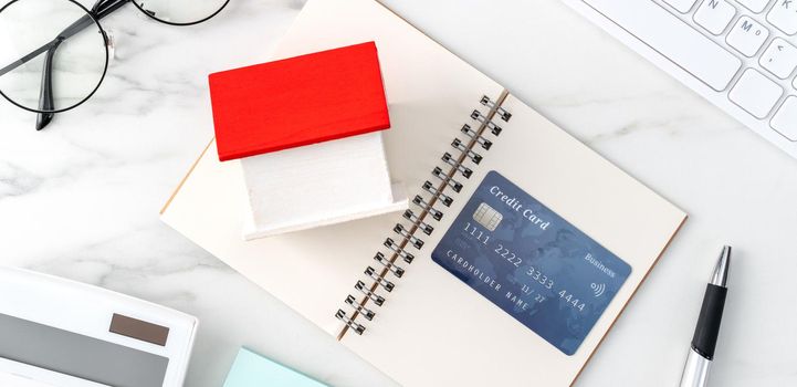 Top view of estimating and paying house tax with calculator and credit card from internet.