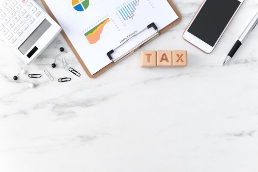 Top view of reading the overview and calculating, paying tax with smart phone from internet.