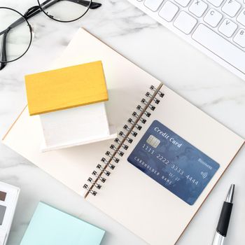 Top view of estimating and paying house tax with calculator and credit card from internet.