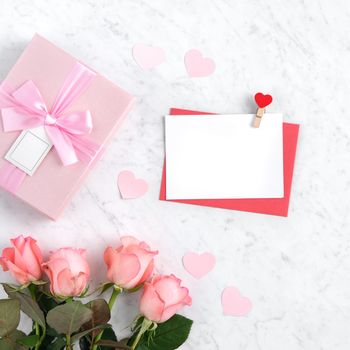 Valentine's Day design concept background with pink rose flower, gift box and card on marble white background