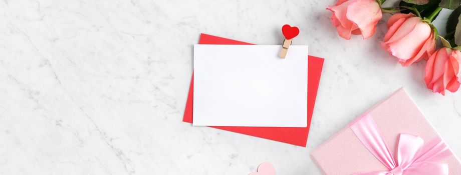 Valentine's Day design concept background with pink rose flower, gift box and card on marble white background