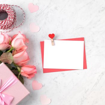 Valentine's Day design concept background with pink rose flower, gift box and card on marble white background