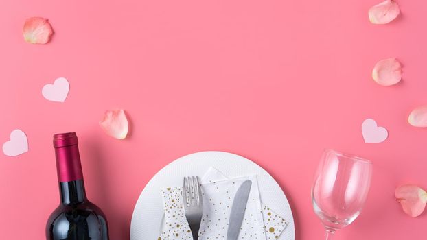 Empty white plate with gift and rose petals for Valentine's Day special holiday dating meal concept.