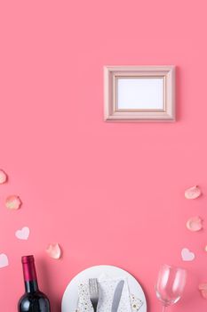 Empty white plate with gift and rose petals for Valentine's Day special holiday dating meal concept.