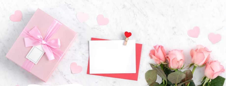 Valentine's Day design concept background with pink rose flower and gift box on marble white background