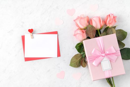 Valentine's Day design concept background with pink rose flower and gift box on marble white background