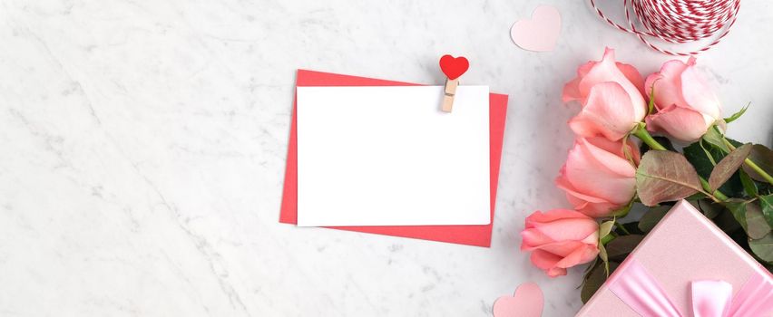 Valentine's Day design concept background with pink rose flower and gift box on marble white background