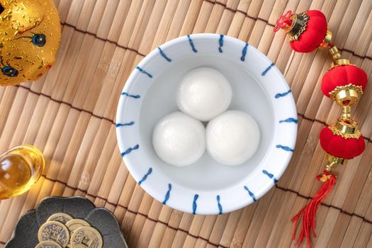 Top view of big tangyuan yuanxiao (glutinous rice dumpling balls) for Chinese lunar new year festival food, words on the golden coin means the Dynasty name it made.