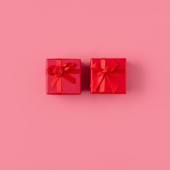Beautiful gift box wrapped with ribbon bow on pastel pink background.