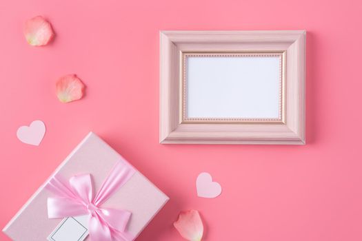 Valentine's Day design concept background with pink petals and gift box on pink background